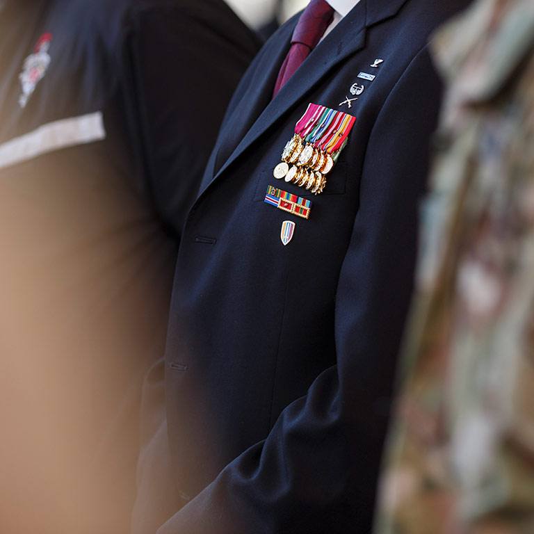 Military medals are displayed on a lapel.